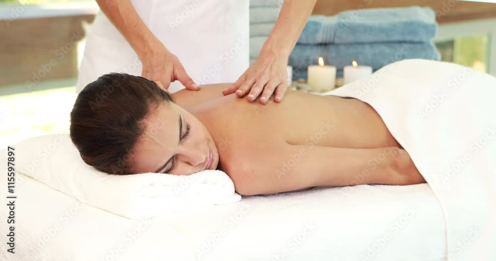 Masseuse giving massage to relax woman in therapy room Masseuse giving massage to relax woman in therapy room