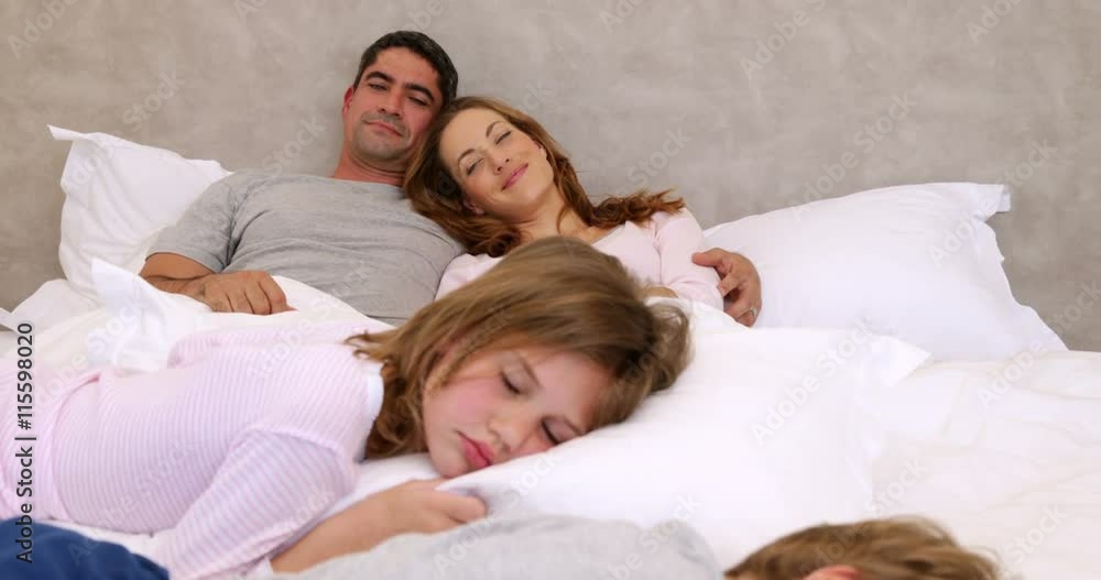 Cute parents and children lying on bed sleeping Cute parents and children lying on bed sleeping