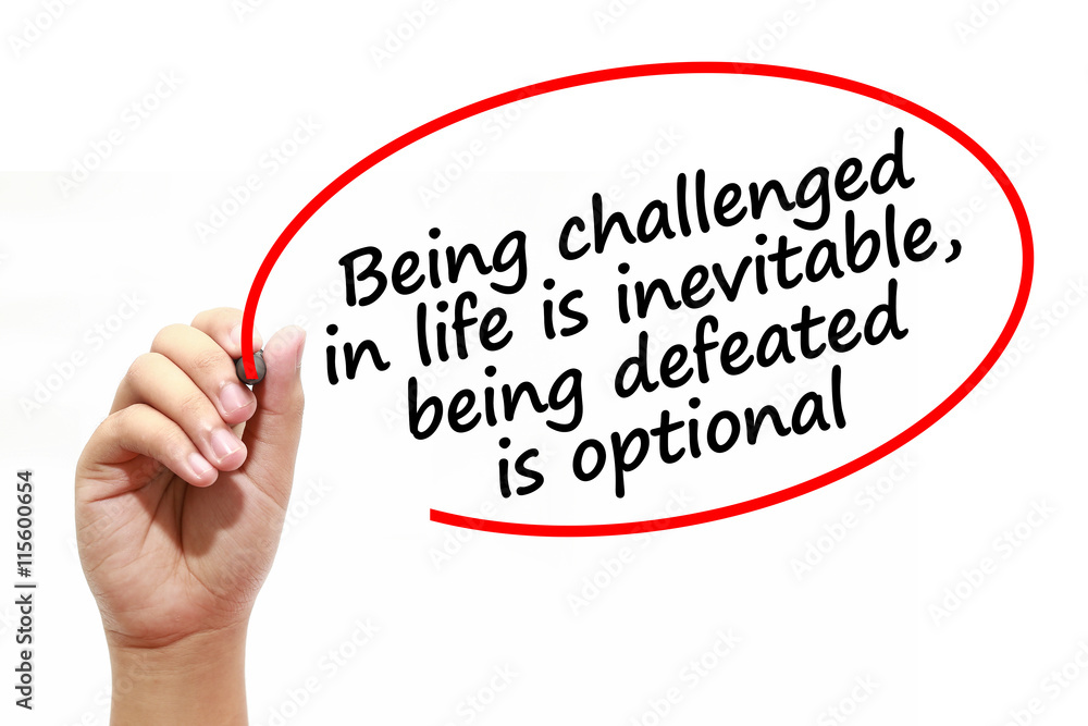 Man writing Being challenged in life is inevitable,being defeated is optional with marker on transparent wipe board. Man writing Being challenged in life is inevitable,being defeated is optional with marker on transparent wipe board.