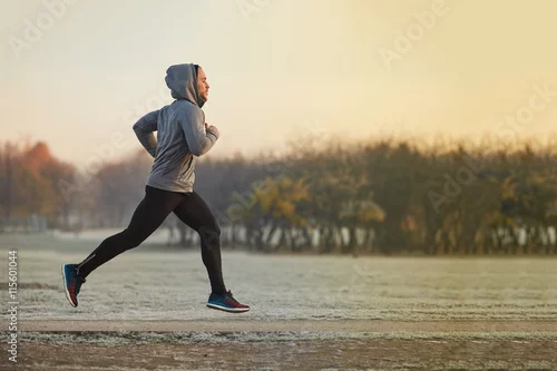 Obraz Młody atletyczny mężczyzna bieg przy parkiem podczas zimnego jesień ranku