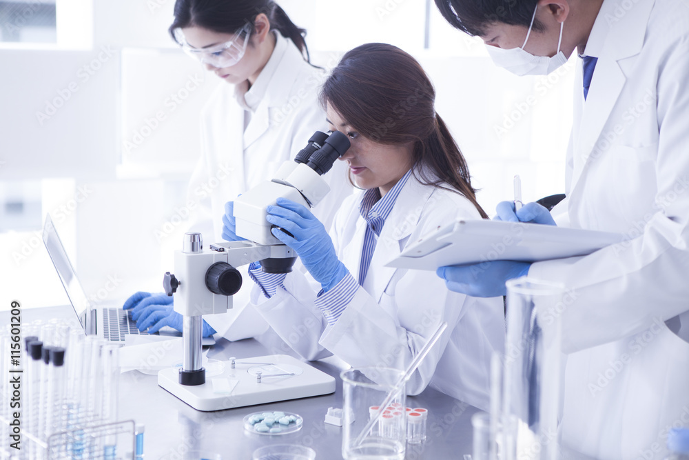 Researchers are analyzing a microscope Researchers are analyzing a microscope