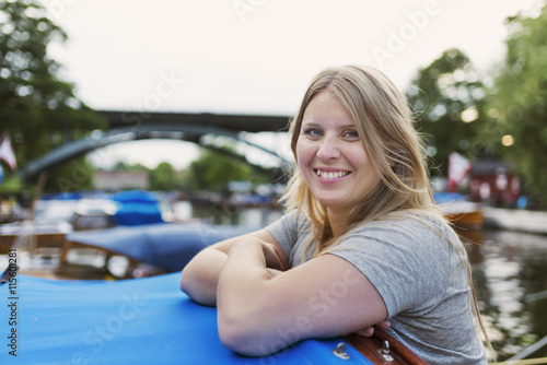 Sweden, Stockholm, Sodermalm, Portrait of smiling woman leaning on boat canopy