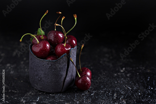 Billede på lærred Fresh sweet cherries in black cup