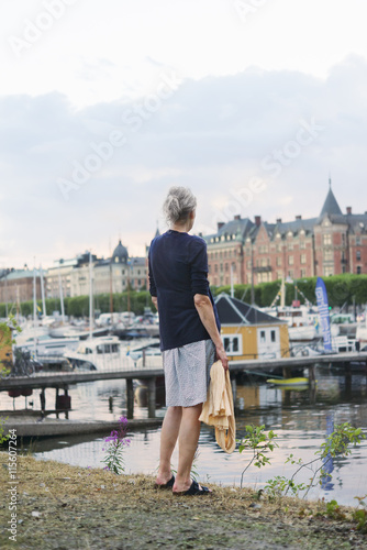 Sweden, Stockholm, Nybroviken, Rear view of woman on riverbank photo