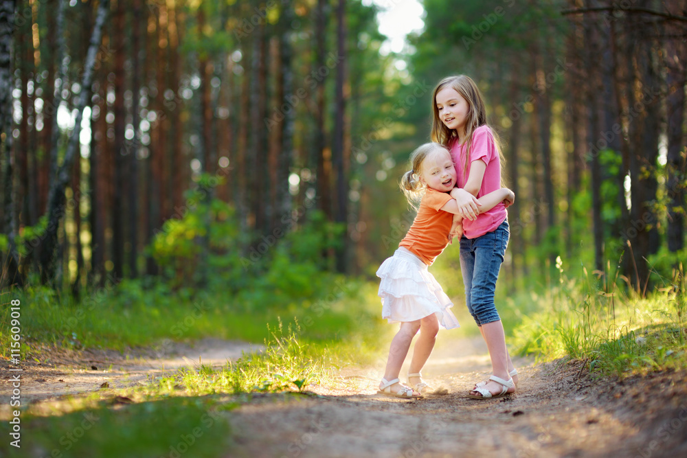 Two adorable little sisters hiking in a forest on summer Two adorable little sisters hiking in a forest on summer