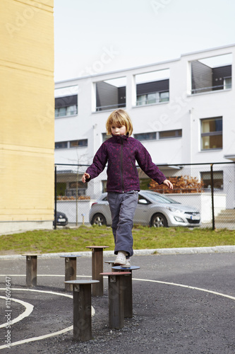 Sweden, Vastra Gotaland, Goteborg, Hisingen, Fargenas, Girl (6-7) walking on wooden posts
