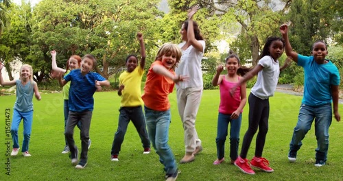 Teacher and pupils dancing together outside the elementary school