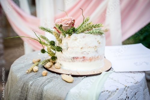 wedding cake with rose and peanuts in old style on table