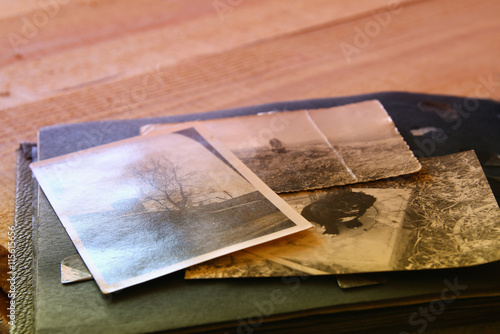 Antique photos and old album on wooden table