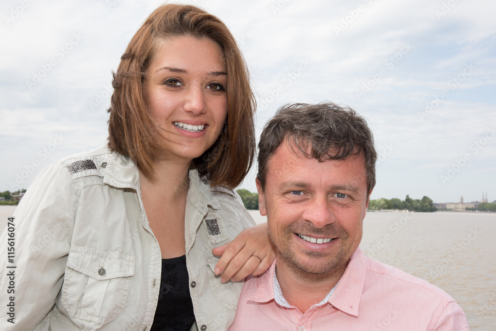 Happy couple standing close to river hugging each other Happy couple standing close to river hugging each other