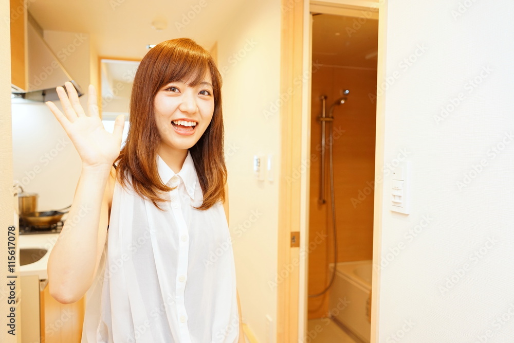 一人暮らしの部屋にお客さんを招き入れる日本人の若い女性 一人暮らしの部屋にお客さんを招き入れる日本人の若い女性