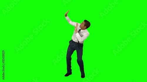 Businessman standing with arms raised on green screen background