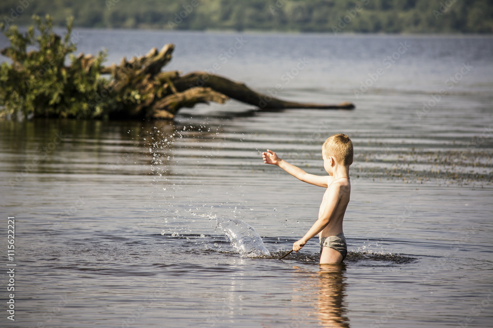 Fototapeta premium Boy playing in the water in summer