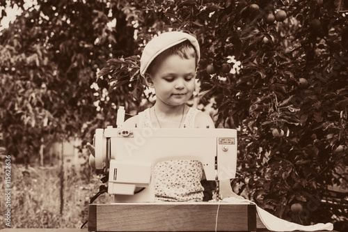 boy at the sewing machine sews in nature