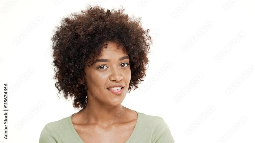Shy young beautiful african girl smiling over white background. Slow motion. Shy young beautiful african girl smiling over white background. Slow motion.