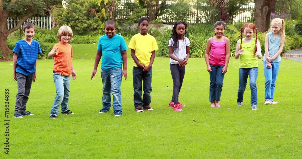 Row of cute pupils racing on the grass outside the elementary school Row of cute pupils racing on the grass outside the elementary school