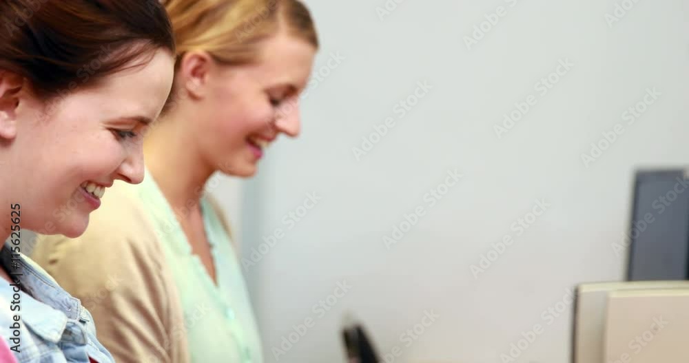 Happy students using computers in the computer room 