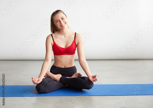 Woman making yoga meditation in lotus pose on mat © kegfire
