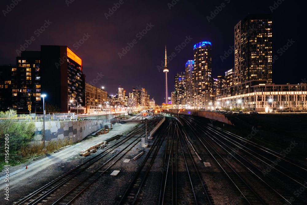 View of a rail yard and modern buildings in downtown at night, f