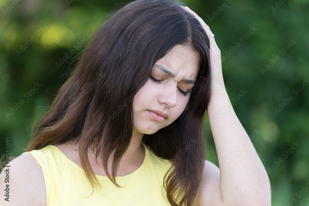 upset teen girl holding a hand behind head upset teen girl holding a hand behind head