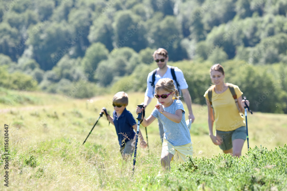 Hiking family walking together in mountain path Hiking family walking together in mountain path