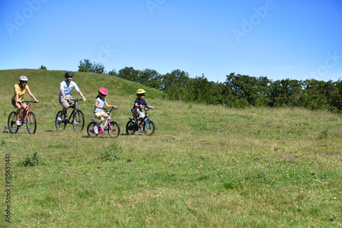 Parents with kids riding bikes in moutain path