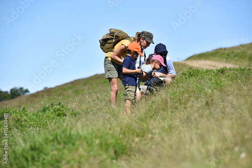 Family on a hiking day looking at vegetation