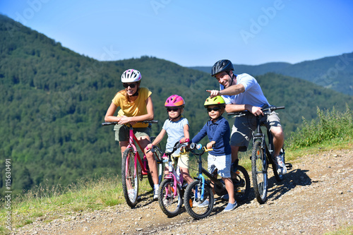 Family on a biking day, parents pointing at scenery