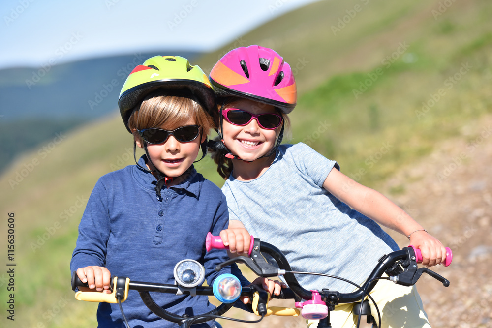 Fototapeta premium Portrait of cheerful kids riding bike