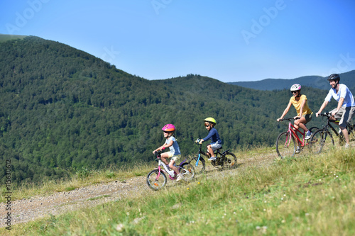 Family of four riding bikes in the mountain