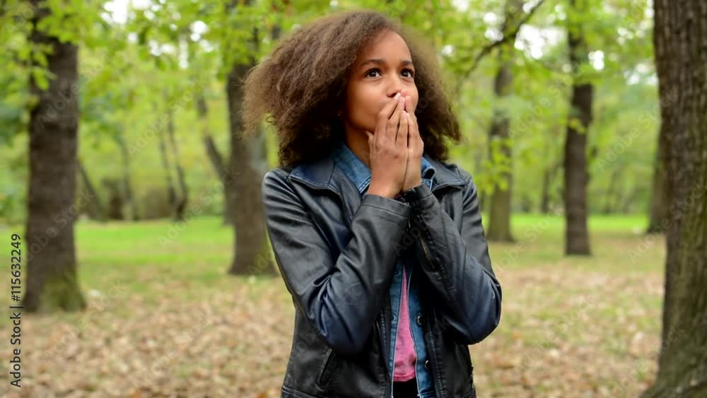young beautiful frightened girl is appear in the unknown forest - she cover her face and looks around through fingers young beautiful frightened girl is appear in the unknown forest - she cover her face and looks around through fingers