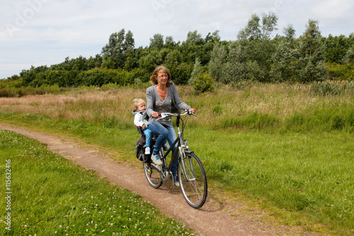 woman with child cycling in nature on a bike path