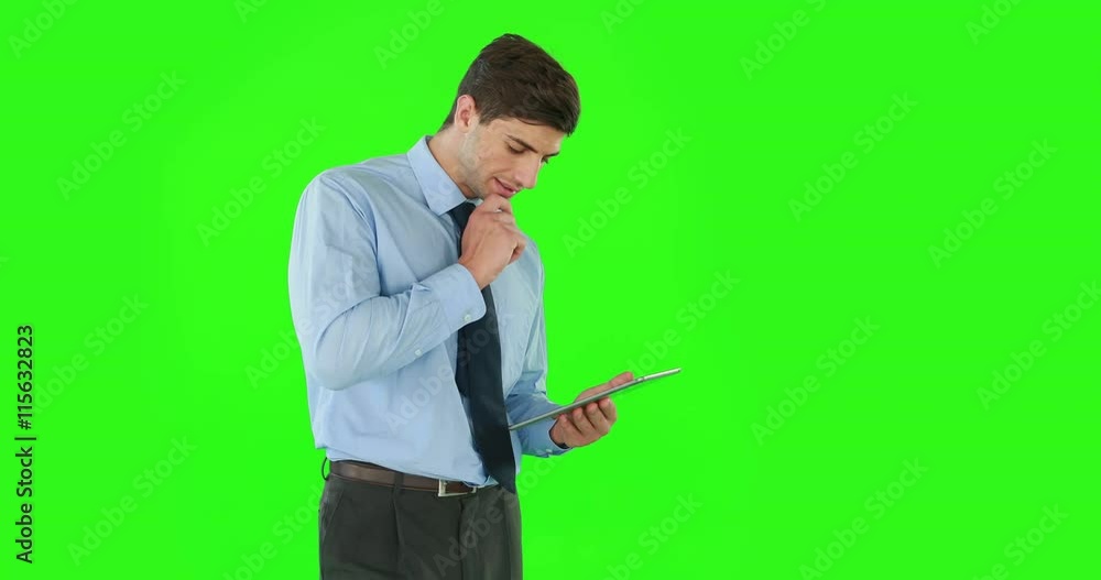 Businessman standing and using a tablet on green screen Businessman standing and using a tablet on green screen