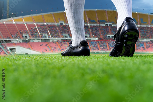 Foot of soccer player or football player walk on green grass ready to play soccer match for the winner with soccer stadium backgrounds.