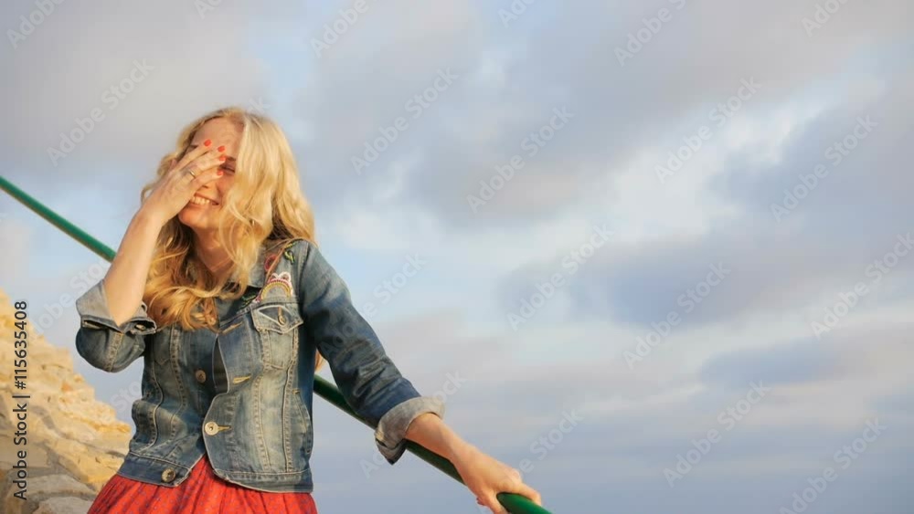 Romantic blonde girl smile and laugh. Coast view near the beach Romantic blonde girl smile and laugh. Coast view near the beach