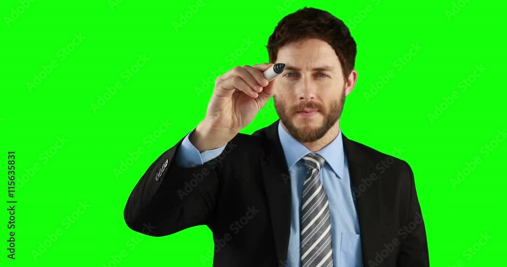 Businessman writing on an invisible board on green screen Businessman writing on an invisible board on green screen