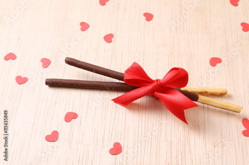 Pair of chocolate dipped biscuit sticks tied to ribbon