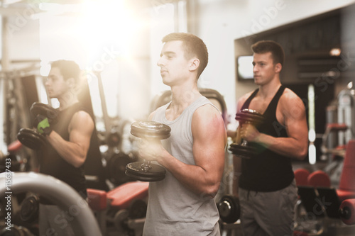 group of men with dumbbells in gym