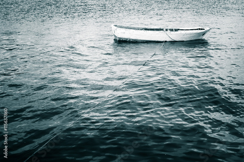 White wooden fishing boat floats on still Sea