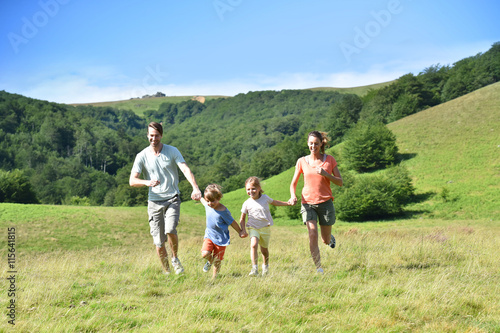 Family on vacation running down the hill