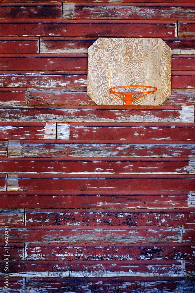 Naklejka premium Old Basketball Hoop on Red Barn Wall