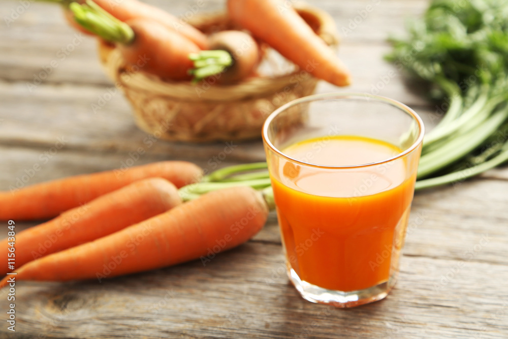 Fresh carrot juice in glass on a grey wooden table Fresh carrot juice in glass on a grey wooden table