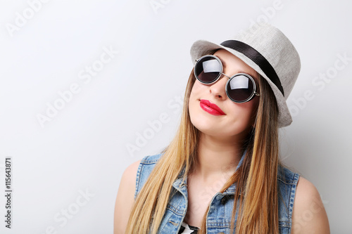 Portrait of a beautiful hipster girl on grey background