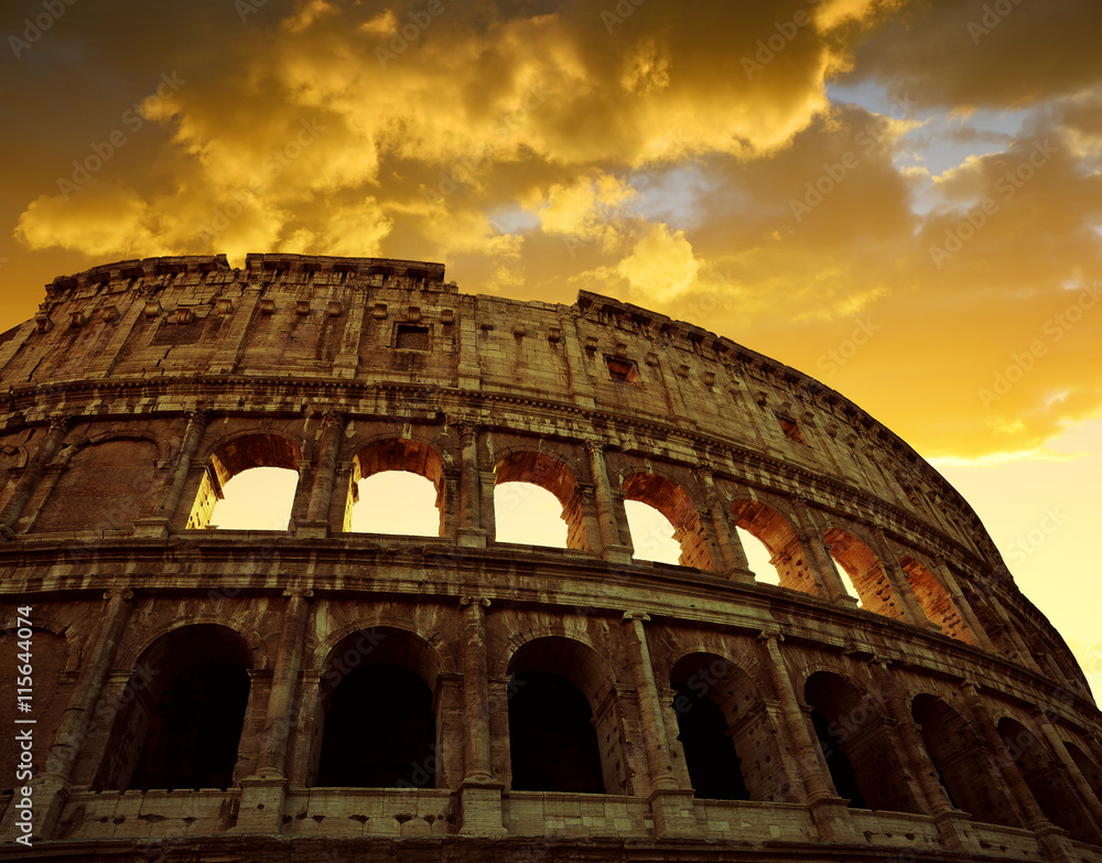 Colosseum in Rome with sunset sky in the background, Italy