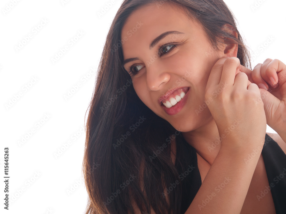 young woman with long straight hair smiling putting on earring young woman with long straight hair smiling putting on earring