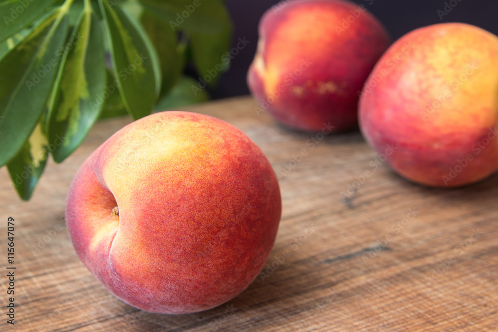 Fresh peaches on a wooden cutting board. Fresh peaches on a wooden cutting board.