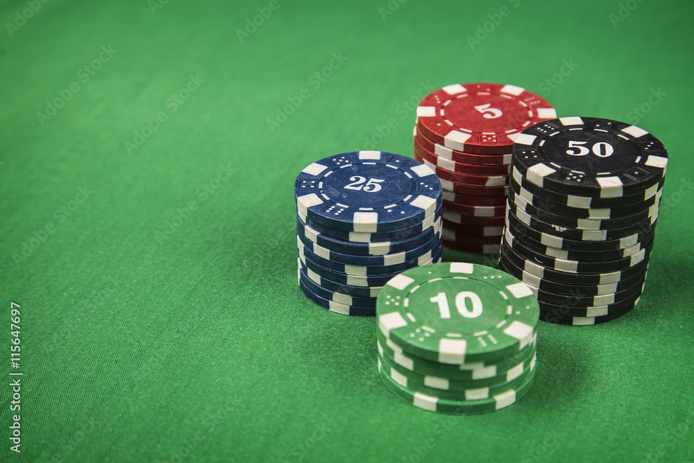 Gambling chips and poker card on green felt background