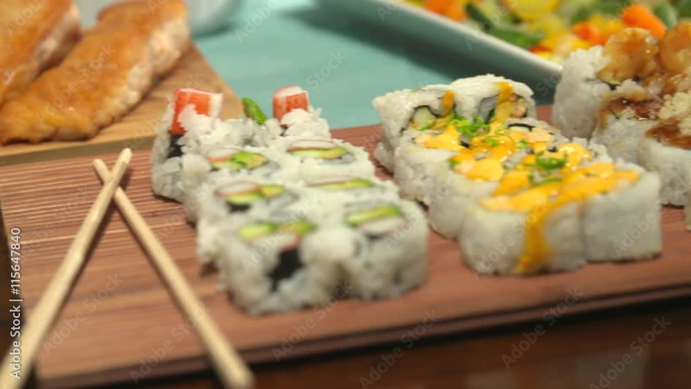 Sushi Close Up Move Right and Left on a Table Spread. camera moves right and left over a variety of sushi with chop sticks, surrounded by a variety of other foods for a party
Sushi Close Up Move Right and Left on a Table Spread. camera moves right and left over a variety of sushi with chop sticks, surrounded by a variety of other foods for a party
