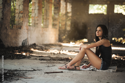 Young woman sitting in abandoned building
