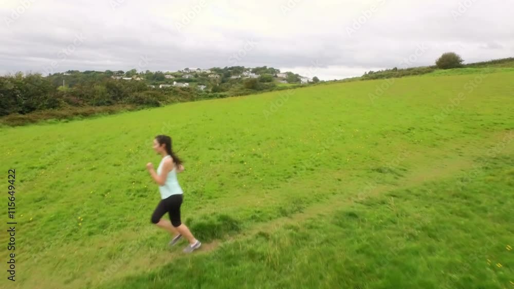 Aerial view of a fit woman running in a green landscape Aerial view of a fit woman running in a green landscape